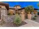 Beautiful front entrance with stone accents, landscaped yard, and wrought iron gate at 42101 N Olympic Fields Ct, Anthem, AZ 85086