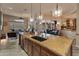 Spacious kitchen featuring a large island with bar seating, modern lighting, and open living area at 42101 N Olympic Fields Ct, Anthem, AZ 85086