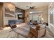 Bright living room with fireplace, comfortable seating, and views of desert landscape at 42101 N Olympic Fields Ct, Anthem, AZ 85086
