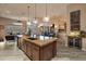 Modern living space featuring a kitchen island, living room, and bar, perfect for entertaining guests at 42101 N Olympic Fields Ct, Anthem, AZ 85086