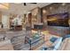 Inviting living room with modern fireplace, stylish furnishings, and seamless flow into the kitchen at 42101 N Olympic Fields Ct, Anthem, AZ 85086