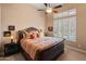 This main bedroom features a large bed, ceiling fan and lots of natural light at 42101 N Olympic Fields Ct, Anthem, AZ 85086
