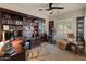 A home office features custom built-in shelving, complemented by a seating area and exercise equipment at 42101 N Olympic Fields Ct, Anthem, AZ 85086