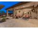 Extensive covered patio with stone columns, multiple seating areas, ceiling fans, and outdoor lighting at 42101 N Olympic Fields Ct, Anthem, AZ 85086