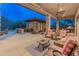The covered patio has an outdoor kitchen and comfortable seating areas at 42101 N Olympic Fields Ct, Anthem, AZ 85086