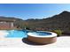 Beautiful backyard pool with an attached spa, set against a backdrop of a natural desert landscape at 42101 N Olympic Fields Ct, Anthem, AZ 85086