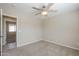 This bedroom offers neutral tones, carpet, a ceiling fan and a view through the doorway at 43205 W Oster Dr, Maricopa, AZ 85138