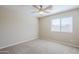 This bedroom offers soft tones, carpet, a ceiling fan and a window offering lots of natural light at 43205 W Oster Dr, Maricopa, AZ 85138