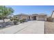 Well-kept single-story home with tandem three-car garage and a mature mesquite tree in front at 43205 W Oster Dr, Maricopa, AZ 85138