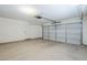 Clean, empty garage with white walls, concrete floor, and a large door at 43205 W Oster Dr, Maricopa, AZ 85138