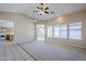 Spacious living room with carpet, tile flooring, and large windows providing plenty of natural light at 43205 W Oster Dr, Maricopa, AZ 85138
