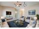 Virtually staged living room with modern furniture, TV, carpet, and neutral walls at 43205 W Oster Dr, Maricopa, AZ 85138