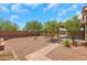 Spacious backyard features low-maintenance desert landscaping and a covered patio with brick trim and an open-air design at 4853 N 183Rd Ln, Goodyear, AZ 85395
