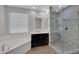 Bathroom featuring dual vanity, soaking tub, and glass-enclosed tiled shower at 4853 N 183Rd Ln, Goodyear, AZ 85395