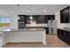 Spacious kitchen featuring an island, stainless steel appliances, and ample dark wood cabinets with modern lighting at 4853 N 183Rd Ln, Goodyear, AZ 85395