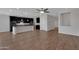 Open concept living area with wood-look tile floors, and kitchen featuring an island and stainless steel appliances at 4853 N 183Rd Ln, Goodyear, AZ 85395