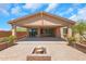Covered patio provides ample space for outdoor living, with brick trim, a fire pit, and multiple sliding glass doors at 4853 N 183Rd Ln, Goodyear, AZ 85395