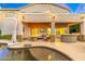 Gorgeous backyard patio with outdoor kitchen, a TV and fire pit by the beautiful pool at 4960 E Colonial Dr, Chandler, AZ 85249