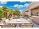 Inviting outdoor dining space overlooking a serene pool with water features, surrounded by lush landscaping and a covered patio at 4960 E Colonial Dr, Chandler, AZ 85249