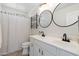 Bright bathroom with dual sinks, decorative mirrors, and shower with patterned curtain at 4960 E Colonial Dr, Chandler, AZ 85249