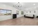 Spacious bedroom with modern light fixture, multiple windows, and light hardwood floors at 4960 E Colonial Dr, Chandler, AZ 85249