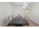 Bright dining room with a dark wood table and modern lighting fixture at 4960 E Colonial Dr, Chandler, AZ 85249