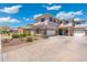 Stately two-story home featuring stone accents, a three-car garage, and a well-manicured front yard at 4960 E Colonial Dr, Chandler, AZ 85249
