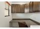 Home office area with built-in desk and upper cabinets providing ample storage and workspace, with a window at 4960 E Colonial Dr, Chandler, AZ 85249