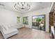 Sunlit living room features a white sofa, a modern chandelier, and sliding doors to the outdoor patio at 4960 E Colonial Dr, Chandler, AZ 85249