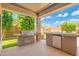 Covered outdoor kitchen with stainless steel grill, built-in bar area, and plenty of space to entertain guests at 4960 E Colonial Dr, Chandler, AZ 85249