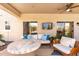 Cozy covered patio area with comfortable seating, ceiling fan, and TV for outdoor entertainment at 4960 E Colonial Dr, Chandler, AZ 85249