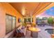 Relaxing covered patio with a fire pit, lounge seating, outdoor kitchen, and backyard views at 4960 E Colonial Dr, Chandler, AZ 85249