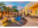 Stunning outdoor space featuring a freeform pool with rock waterfall, tropical plants and a cozy lounge area at 4960 E Colonial Dr, Chandler, AZ 85249