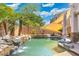 Lush backyard pool area with rock waterfall feature and mature palm trees, perfect for relaxation at 4960 E Colonial Dr, Chandler, AZ 85249