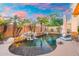 Backyard oasis featuring a waterfall pool, lush landscaping, and string lights for evening ambiance at 4960 E Colonial Dr, Chandler, AZ 85249