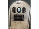 Inviting foyer with decorative mirrors, wooden console table, and tiled flooring design at 5143 W Mountain View Rd, Glendale, AZ 85302
