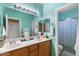 Bright bathroom featuring double sinks and a shower with decorative blue curtain at 5212 S Monte Vista St, Chandler, AZ 85249