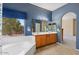 Stylish bathroom with dual sinks, spacious countertops, a soaking tub, and neighborhood views at 5212 S Monte Vista St, Chandler, AZ 85249
