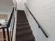 Carpeted staircase with black metal railing and white brick wall at 5446 W Sheena Dr, Glendale, AZ 85306