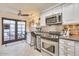 Bright kitchen with stainless steel appliances, bar seating, and patio access at 6131 N 28Th Pl, Phoenix, AZ 85016