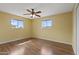 Bright bedroom with wood floors, two windows and neutral paint at 6217 E Dodge St, Mesa, AZ 85205