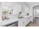 Bright kitchen boasts white cabinets, stainless steel appliances, and a large island for seamless food preparation and entertaining at 6359 S Forest Ave, Gilbert, AZ 85298