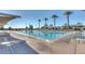 Luxurious community swimming pool featuring lap lanes, lounge chairs, shade and swaying palm trees at 6359 S Forest Ave, Gilbert, AZ 85298