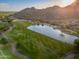 Stunning aerial view of a golf course with a serene pond, set against a desert landscape with mountain backdrop at 6939 S Red Hills Rd, Gold Canyon, AZ 85118
