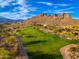Aerial shot of a vibrant green golf course winding through a desert landscape with mountain backdrop at 6939 S Red Hills Rd, Gold Canyon, AZ 85118