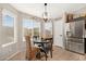Cozy breakfast nook with a round table, large windows, and a view to the kitchen with stainless steel appliances at 6939 S Red Hills Rd, Gold Canyon, AZ 85118