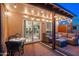 Relaxing covered patio with comfortable seating, string lights, and sliding glass doors to the kitchen at 6939 S Red Hills Rd, Gold Canyon, AZ 85118