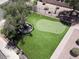 A putting green and lovely landscaping are backyard highlights in this aerial view of the outdoor living space at 713 W Boxelder Pl, Chandler, AZ 85225