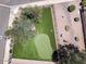 An aerial view shows a lovely putting green and shade tree amongst lush landscaping in the backyard at 713 W Boxelder Pl, Chandler, AZ 85225