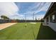 Private backyard with lush artificial turf, a volleyball court, and secure fencing at 7201 N 16Th Dr, Phoenix, AZ 85021